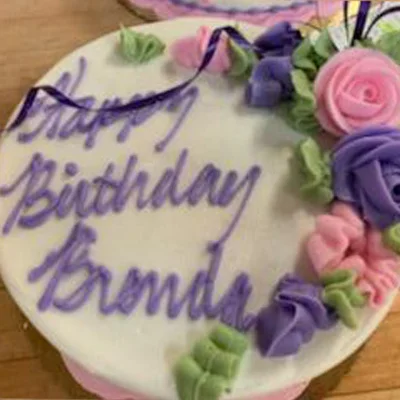 Birthday cake with piped purple script and roses
