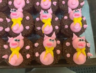 Chocolate cupcakes topped with pink piglets